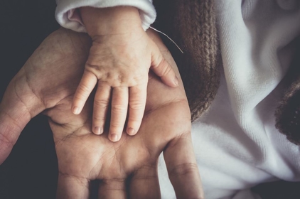 A baby's hand in the parent's hand